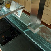 contemporary coastal kitchen design detail. Custom design glass shelf around columns over cooktop