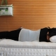 Person laying down on a memory foam mattress to test spine alignment and comfort.