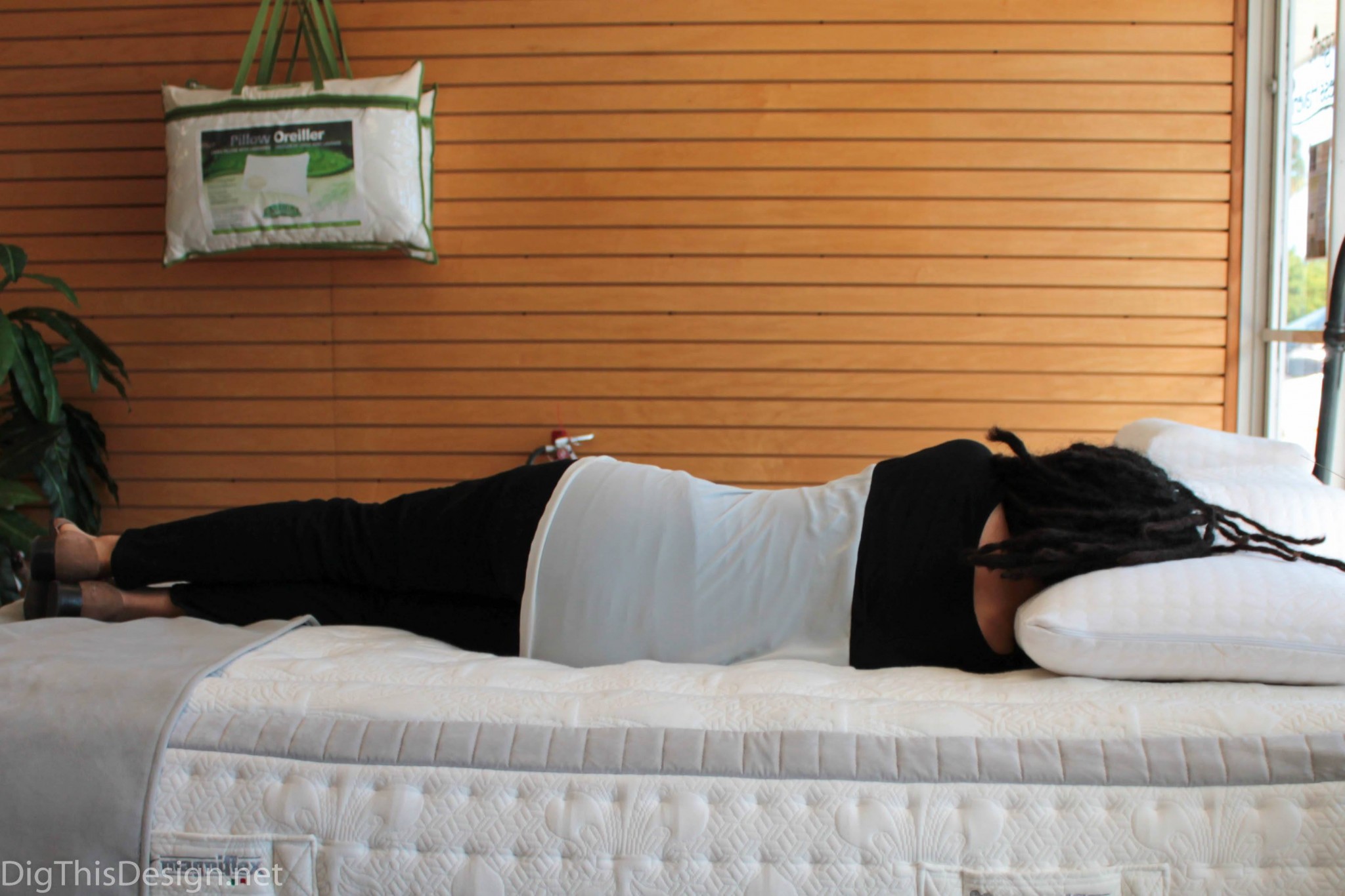 Person laying down on a memory foam mattress to test spine alignment and comfort.