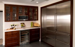 contemporary kitchen wine bar with microwave mounted in wall cabinet shelf, water texture glass cabinet doors, sub zero refrigerators and wine cooler