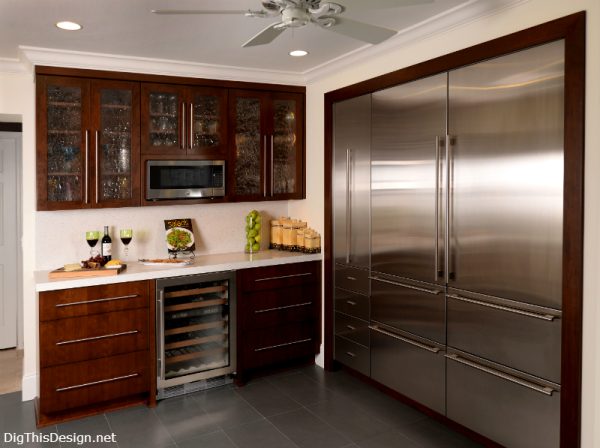 contemporary kitchen wine bar with microwave mounted in wall cabinet shelf, water texture glass cabinet doors, sub zero refrigerators and wine cooler