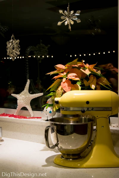 Christmas window sill decor with starfish, yellow Kitchenaid, poinsettia, silver star ornaments