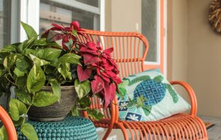 Orange metal rocking chairs in the front porch and matching orange door.