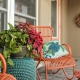 Orange metal rocking chairs in the front porch and matching orange door.