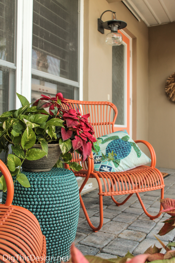 Orange metal rocking chairs in the front porch and matching orange door.