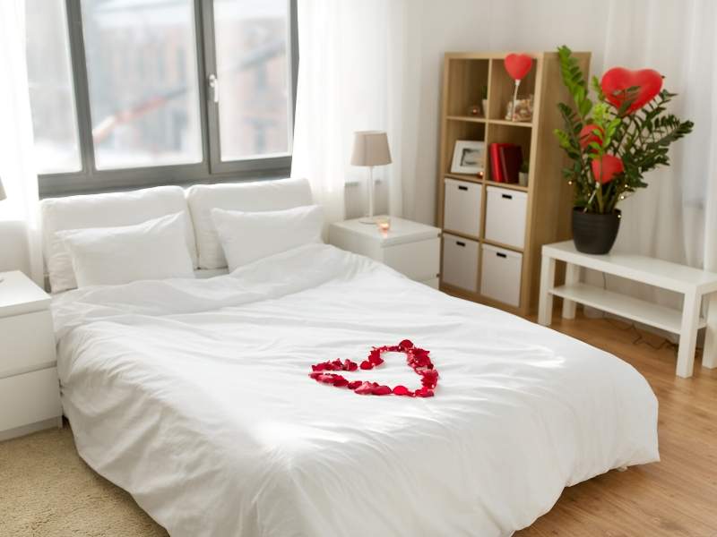 Romantic rose petals in a heart-shaped motif on the bed