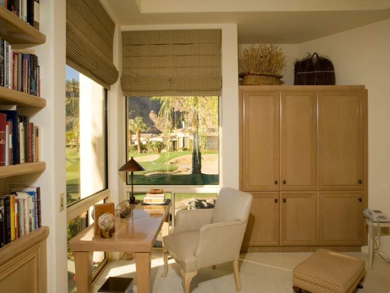 Organic materials in an office including wood shelves and furniture, woven baskets, and lots of natural light.