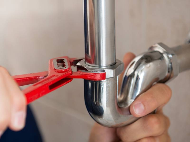 Plumbing Contractors Tightening a Pipe