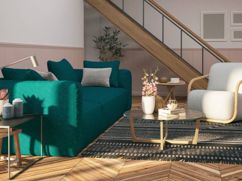 How To Add Color to Your Living Room - dark teal sofa with native pattern rug in modern room.