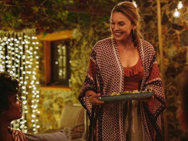 Hosting an Outdoor Evening Dinner Party - woman serving guests at an outdoor party.