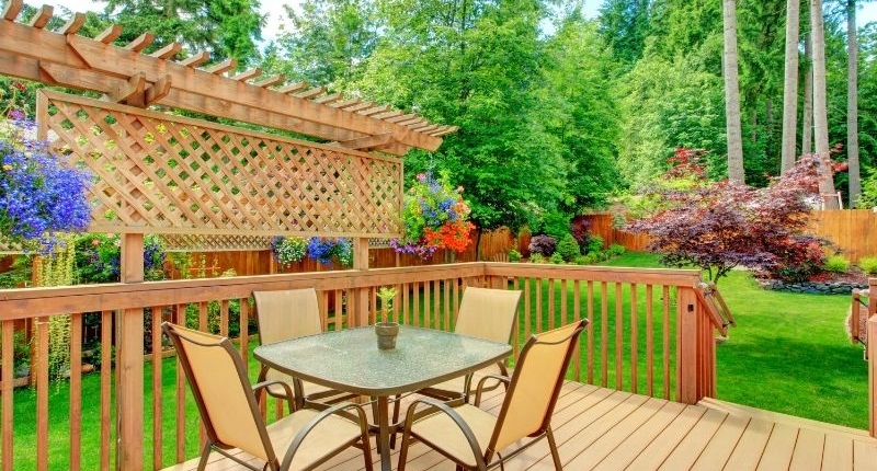 How To Create A Summer-Ready Patio - Patio deck surrounded by a lush green grass lawn.