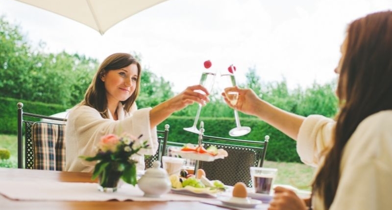 How To Create A Summer-Ready Patio - Friends toasting over a champagne breakfast on the patio.