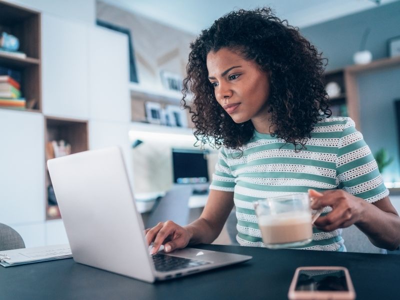 Your Guide To Setting Up A Home Office - Home worker at desk with laptop.