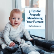 3 Tips for Properly Maintaining Your Furnace - baby sitting by winter window on blue and grey plaid blankets.