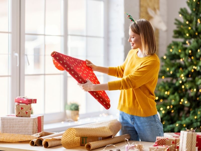 How To Choose Thoughtful Christmas Presents For Loved Ones - lady wrapping presents.