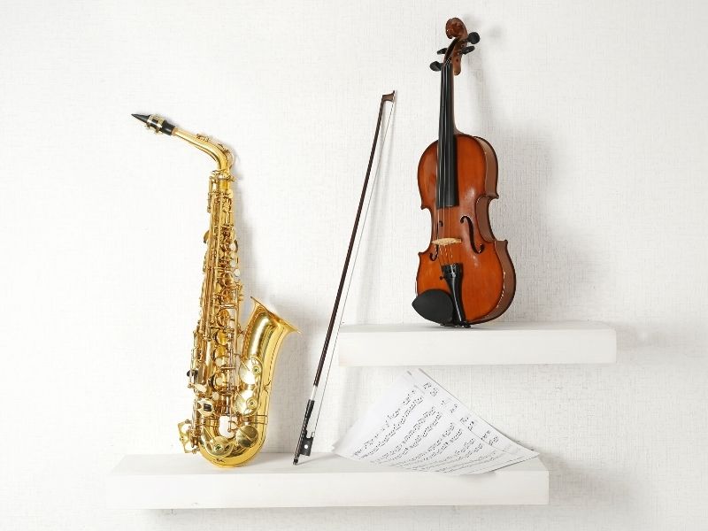 5 Tips To Decorate Your Home With Music Sxaphone and violin sitting on white wall and shelves