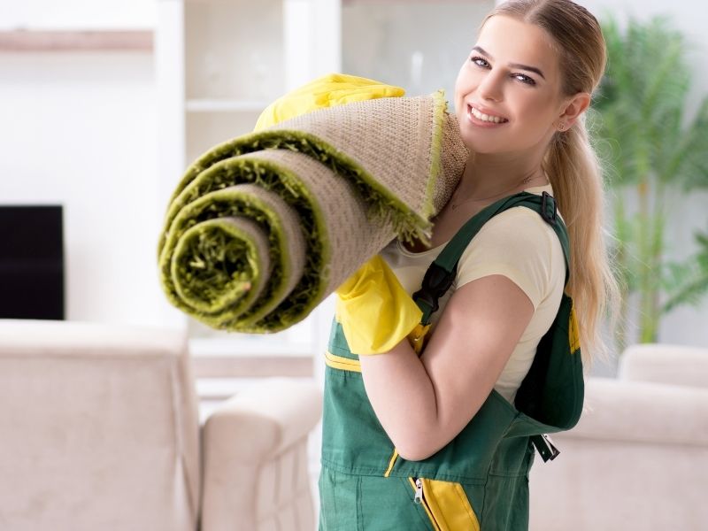 Pro carpet cleaning services with lady holding rolled up rug.