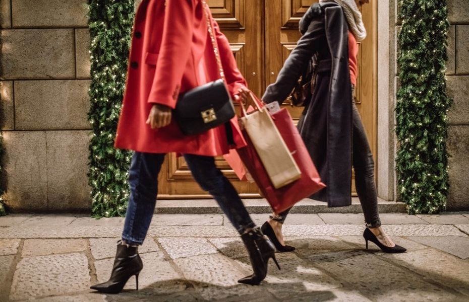 Layering for your winter style - two women shopping in winter coats and boots.