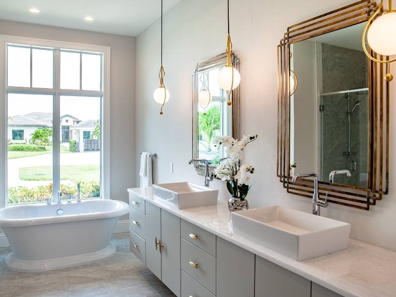 Modern bathroom with 3 pendants hanging over long his and her sinks.