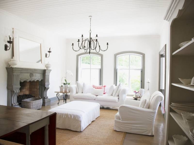 Inspiration for Chandeliers - Large rustic chandelier over classic living room white on white with grey trim.