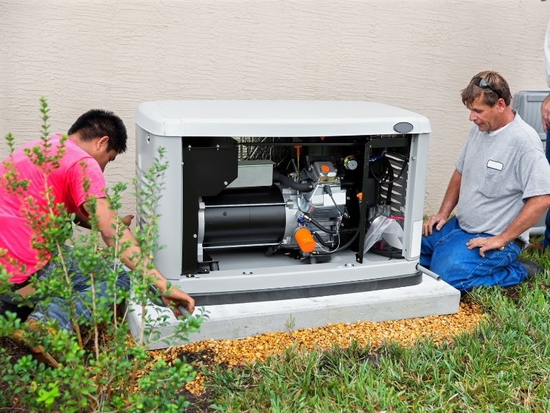 Electricians installing a whole house emergency generator for hurricane season.