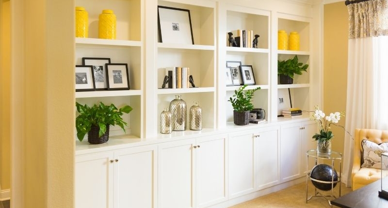 White custom shelving for a yellow wall.