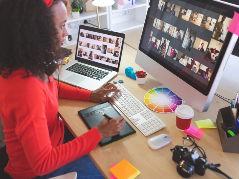 Graphic artists looking through photos on laptop and net book.